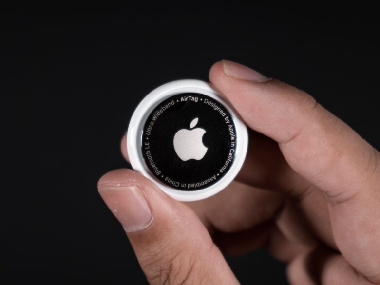 Airtag Photo of an Apple AirTag tracker held between a person's finger and thumb.