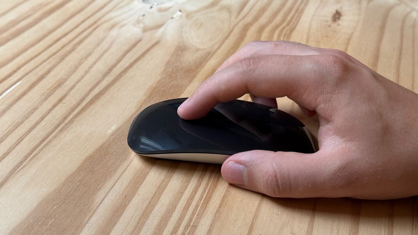 Holding Magic Mouse Holding a Black Magic Mouse