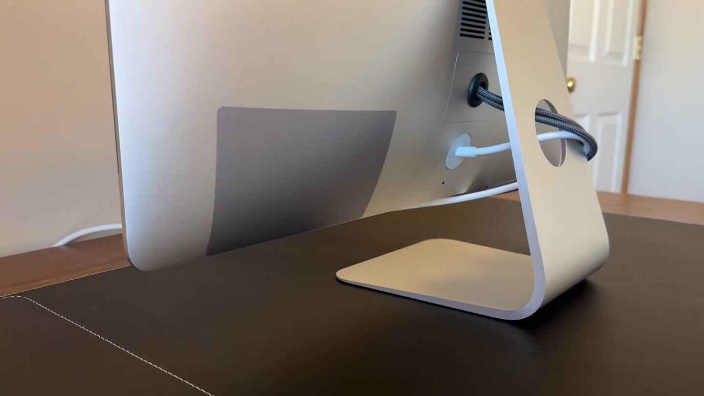 IMac Display Rear iMac rear, with a cover hiding the ports and a nicely reinstalled RAM door with a rubber grommet protecting the cables coming out.