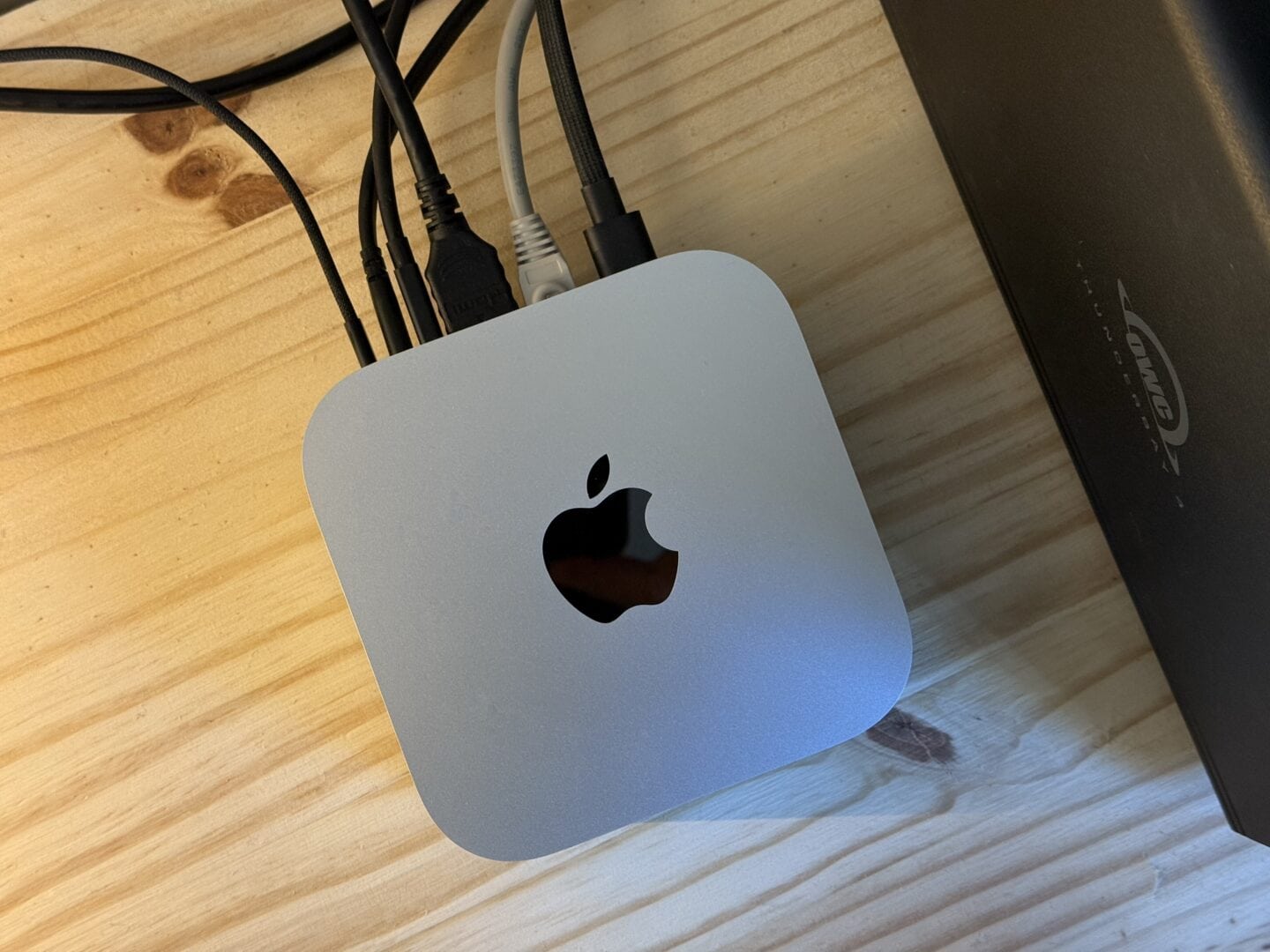 Mac mini M4 cables Mac mini M4 pictured from above, with various things plugged into the back.