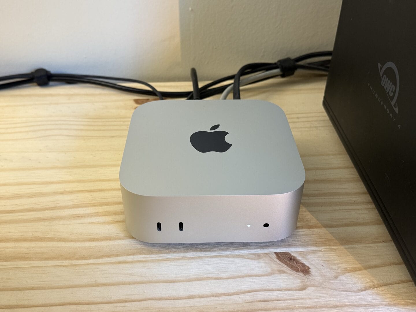 Mac mini M4 on desk plugged in Mac mini M4 sitting on a desk with various cables plugged into the back