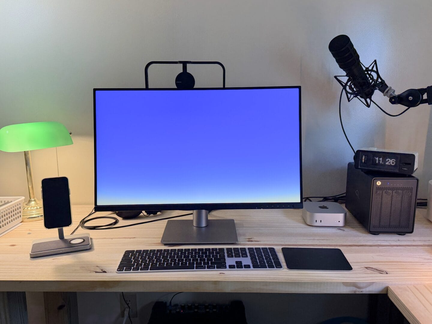 Mac mini M4 setup Mac mini setup with display, keyboard, trackpad, external storage, iPhone mount and podcasting microphone.