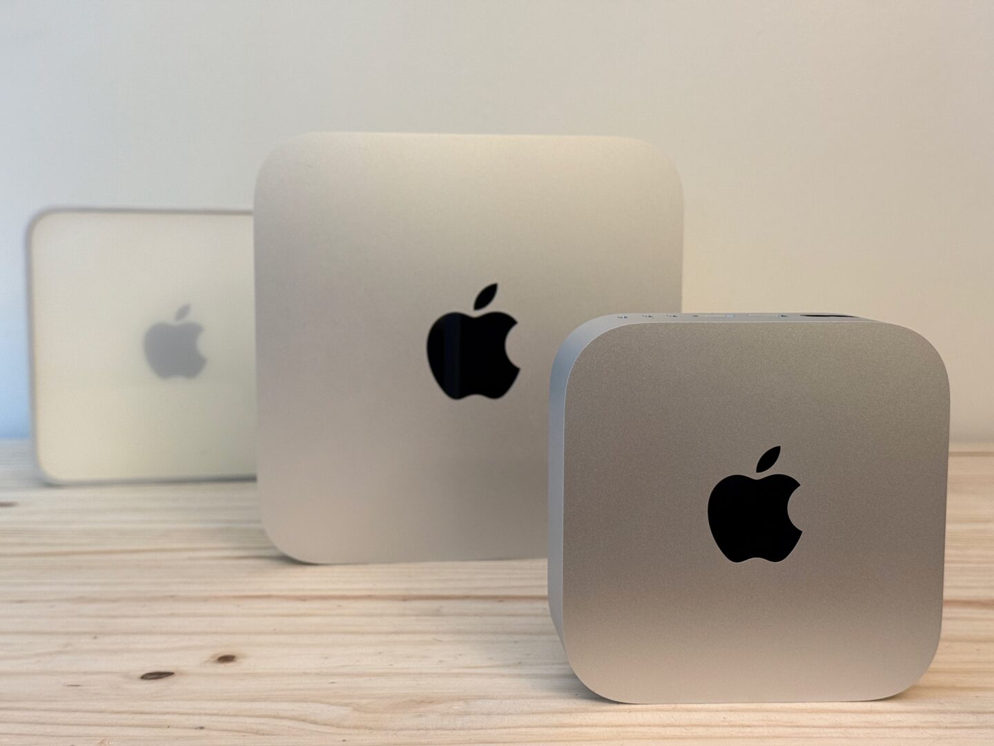 Mac mini Three Generations All three Mac mini designs sitting vertically on a table
